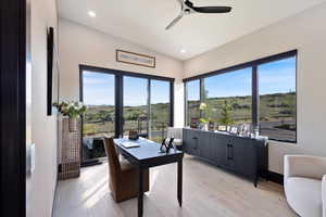 Office area with light wood finished floors, healthy amount of natural light, ceiling fan, recessed lighting, and a rural view