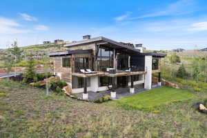 Rear view of property with a patio area, a lawn, and a balcony
