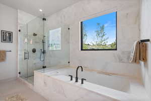 Bathroom with a bath and a marble finish shower