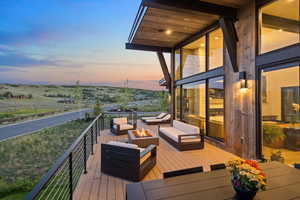 Deck at dusk featuring an outdoor living space with a fire pit