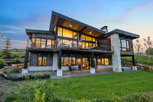 Back of house with a patio area, a balcony, and a lawn