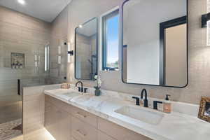 Bathroom featuring a stall shower and double vanity