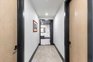 Hallway with recessed lighting and baseboards