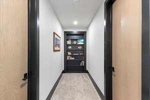 Corridor with baseboards and recessed lighting