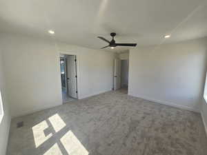Unfurnished bedroom featuring carpet, recessed lighting, ceiling fan, and ensuite bath