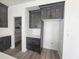 Kitchen with backsplash, dark wood finished floors, and dark brown cabinetry