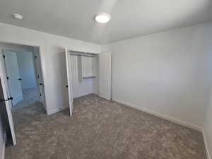 Unfurnished bedroom with a closet, carpet flooring, and a textured ceiling