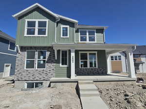View of front of home featuring covered porch and board and batten siding