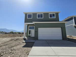 View of front of home with an attached garage, concrete driveway, and a mountain view