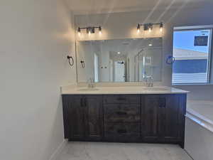 Full bathroom featuring double vanity, a stall shower, and a bath