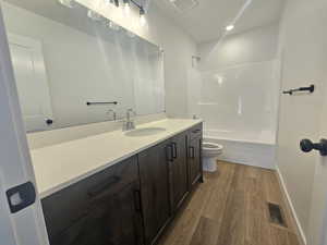 Bathroom featuring vanity, light wood-type flooring, bathing tub / shower combination, and recessed lighting