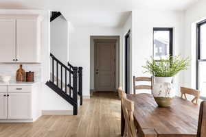 Dining room featuring light wood-type flooring and stairway