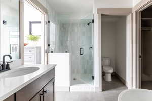 Bathroom with a stall shower, vanity, and light tile patterned flooring