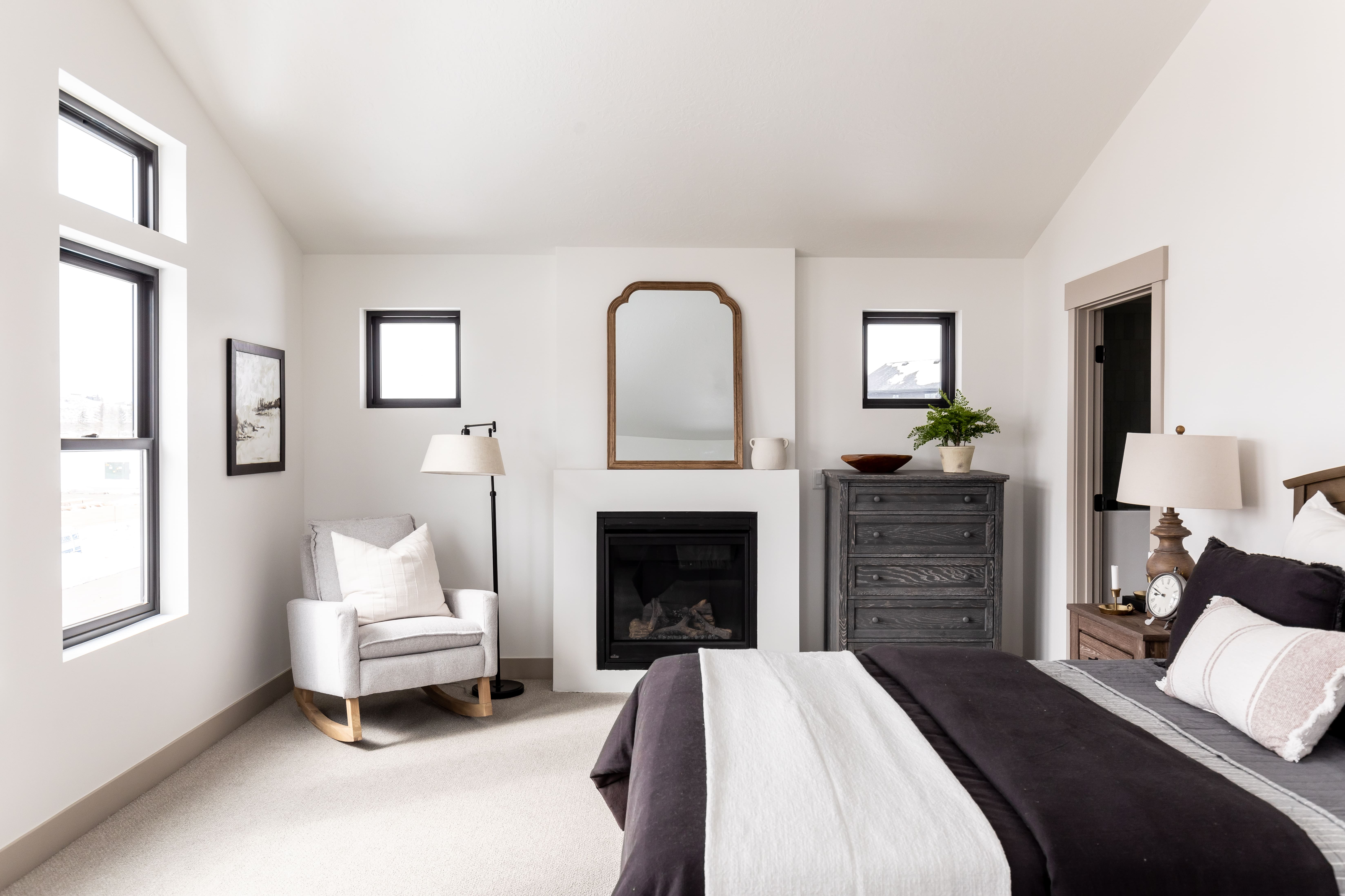 Bedroom featuring lofted ceiling, a glass covered fireplace, and carpet