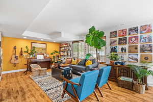 Living area with light wood-type flooring and recessed lighting