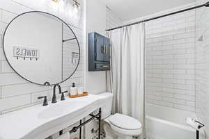 Full bath with shower / tub combo with curtain and toilet