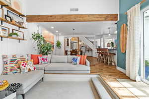 Living room with wood finished floors, recessed lighting, and beamed ceiling