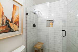 Bathroom featuring a shower stall and toilet