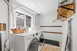 Washroom featuring separate washer and dryer and light tile patterned floors
