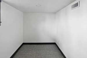 Spare room with a textured ceiling and baseboards