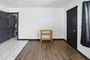 Unfurnished bedroom with a textured ceiling and dark wood-style floors