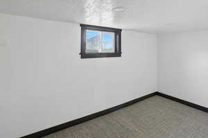 Spare room with baseboards and a textured ceiling