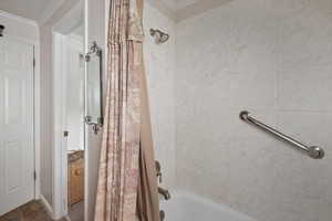 Full bathroom with shower / bathtub combination with curtain and crown molding