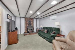 Family room with carpet flooring, a wood stove, and a textured ceiling
