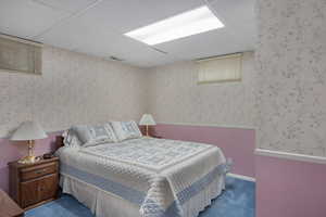 Carpeted bedroom featuring a drop ceiling