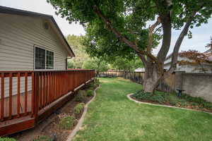 View of the back of the home and deck on North side of the home with View of fenced backyard