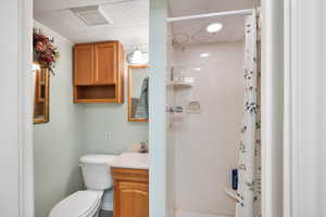 3/4 bathroom featuring a stall shower, vanity, and crown molding