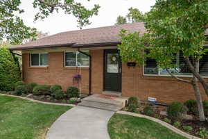 Ranch-style house featuring brick siding, a shingled roof, and a front lawn