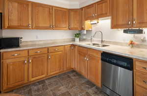 Kitchen featuring dishwasher, brown cabinets, quartz countertops, and crown molding