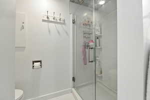 Bathroom with a stall shower and tile patterned floors