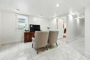 Living room with light marble finish flooring and recessed lighting