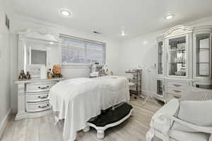 Bedroom featuring ornamental molding, light wood finished floors, and recessed lighting