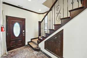 Foyer with crown molding, stairs, and recessed lighting