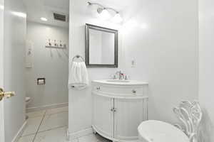 Half bathroom featuring vanity and light marble finish floors