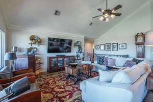 Living area with crown molding, wood finished floors, high vaulted ceiling, and a ceiling fan