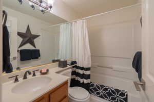 Bathroom featuring shower / bath combo with shower curtain and vanity