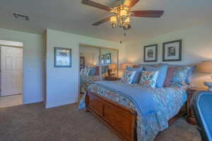 Carpeted bedroom featuring a ceiling fan, a closet, and a textured ceiling