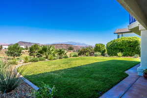 View of green lawn featuring a mountain view