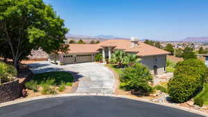 Mediterranean / spanish-style home featuring a garage, a tile roof, driveway, a mountain view, and stucco siding
