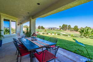 View of patio with outdoor dining space and view of golf course