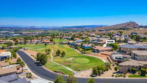 Aerial view of residential area with a mountain backdrop and a golf club
