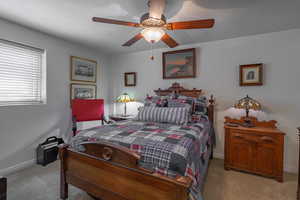 Carpeted bedroom featuring a textured ceiling and ceiling fan