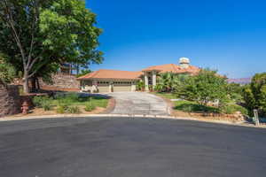 Mediterranean / spanish-style home with an attached garage, concrete driveway, a tile roof, and stucco siding