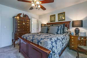 Bedroom featuring carpet flooring, a ceiling fan, and a textured ceiling