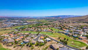 Aerial perspective of suburban area featuring a local golf course and a water and mountain view
