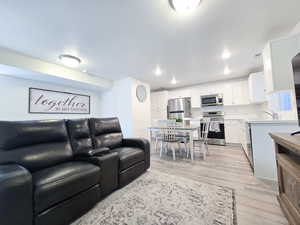 Living area featuring light wood-type flooring and recessed lighting